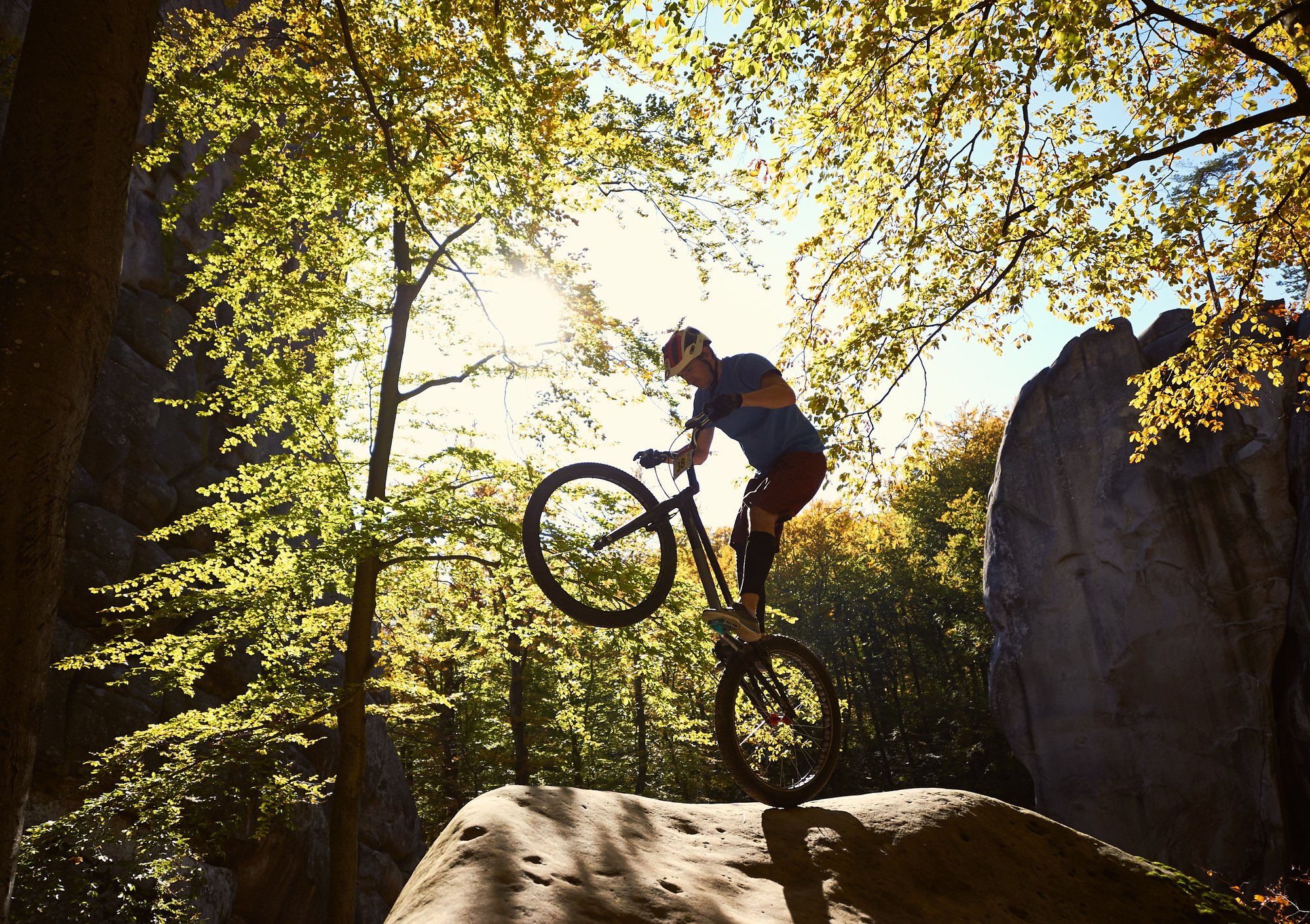 Sportsman cyclist balancing on back wheel on trial bicycle