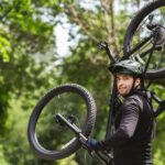Sportsman holding his bike up on the forest path