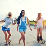 Three young woman skateboarding at the beach