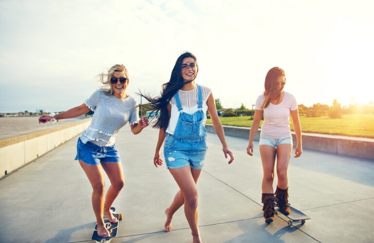 Three young woman skateboarding at the beach