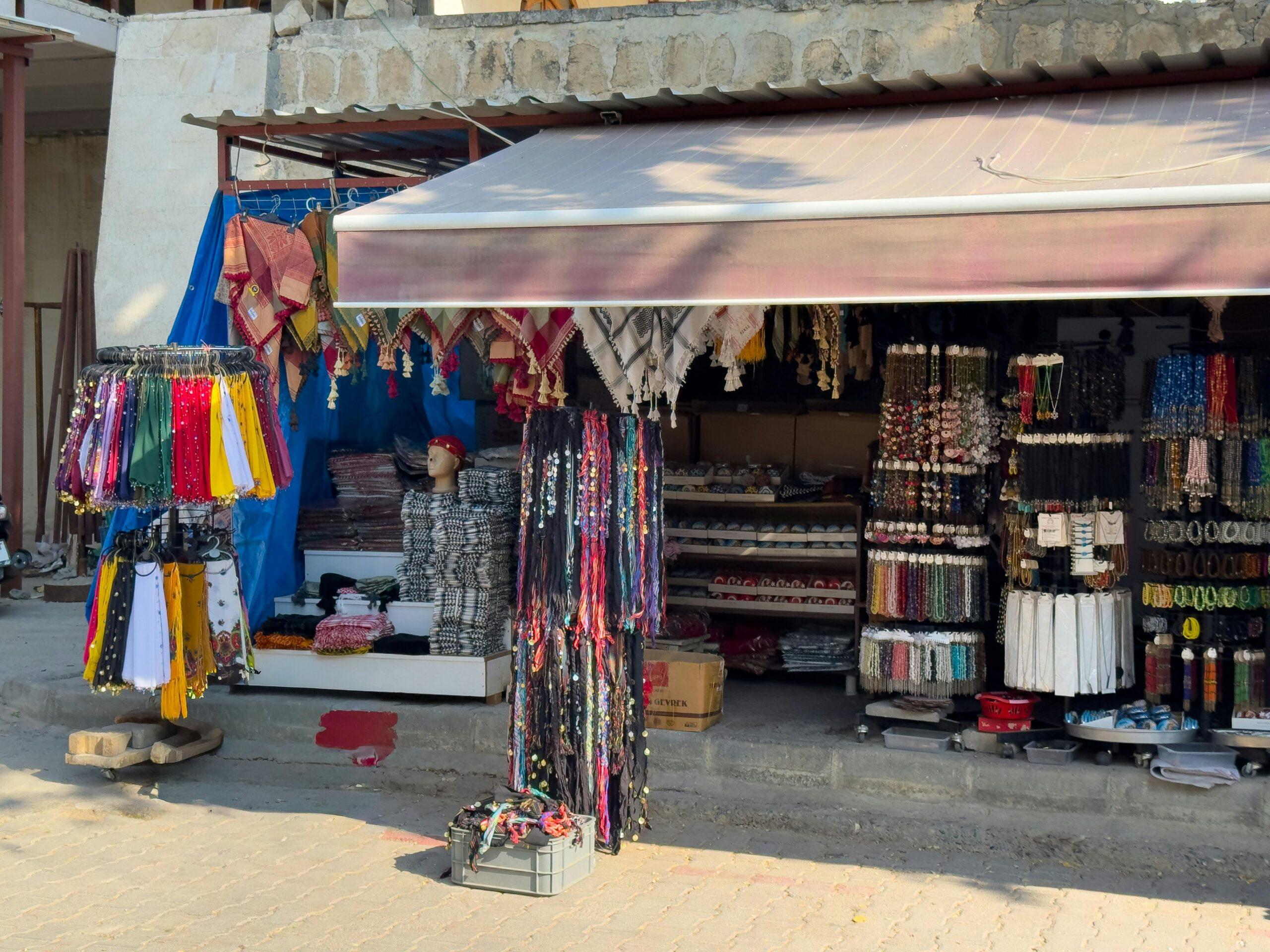 Vibrant textile shop display with scarves and fabrics in Halfeti, Türkiye market.