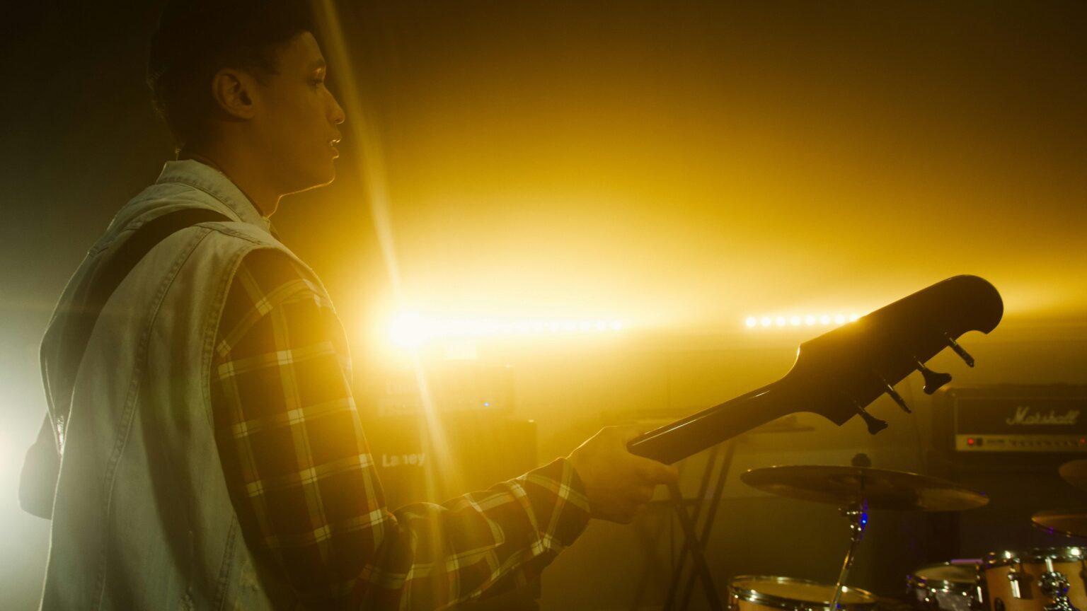 qu’est-ce que le rocker et le cambre des skis et snowboards ? Silhouette of a guitarist playing on stage with dramatic backlighting during a sunset concert.