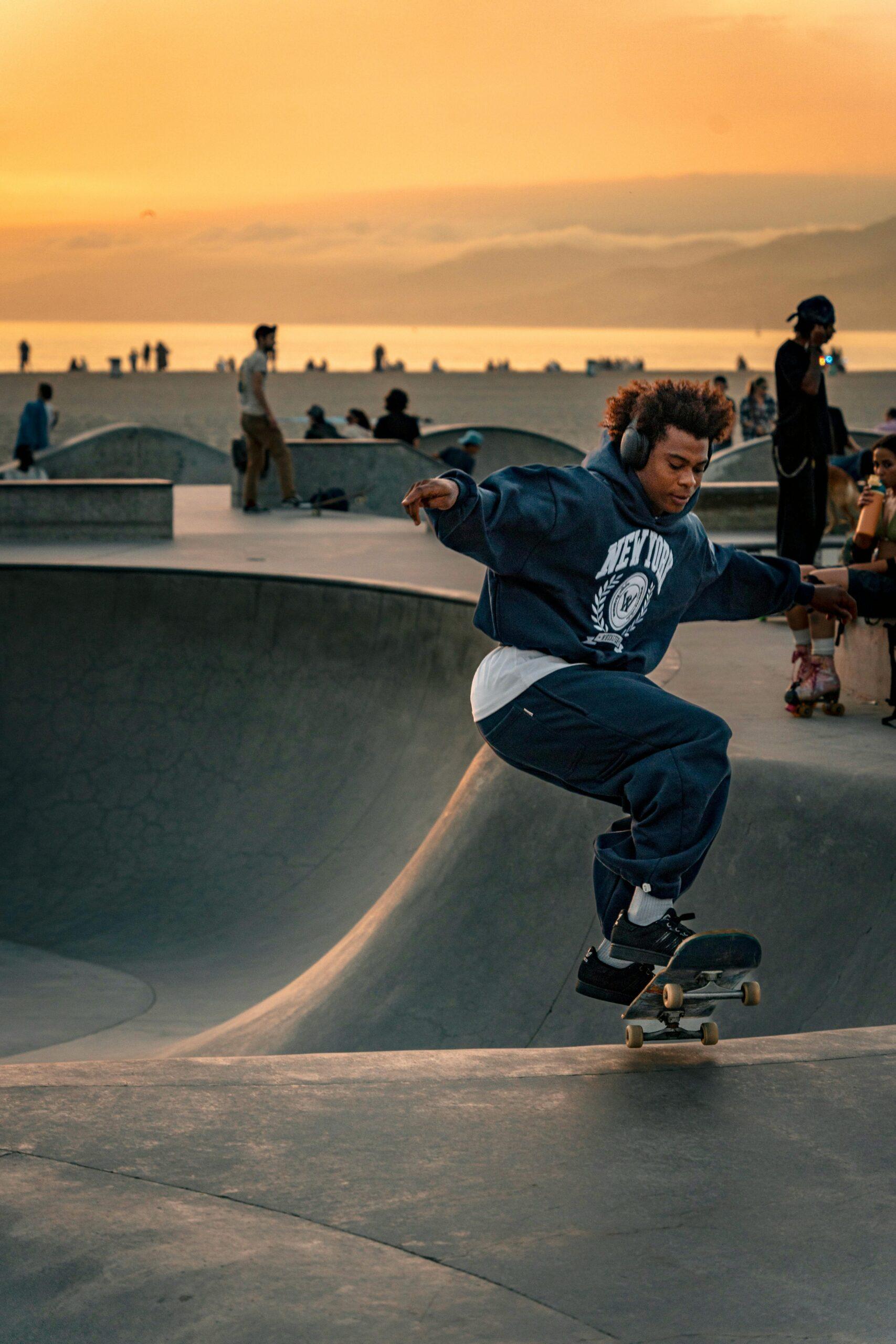 Un café itinérant pour revitaliser la culture du skate Skateboarder performing tricks with headphones at Venice Beach skatepark during sunset in Los Angeles.