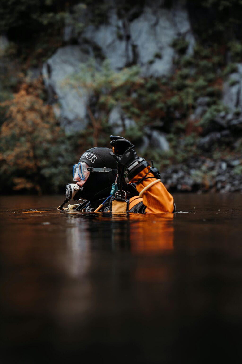 comment sélectionner une combinaison de plongée : épaisseur, indications de température et autres conseils A scuba diver in full gear enjoying a tranquil dive in the calm waters of Wales.